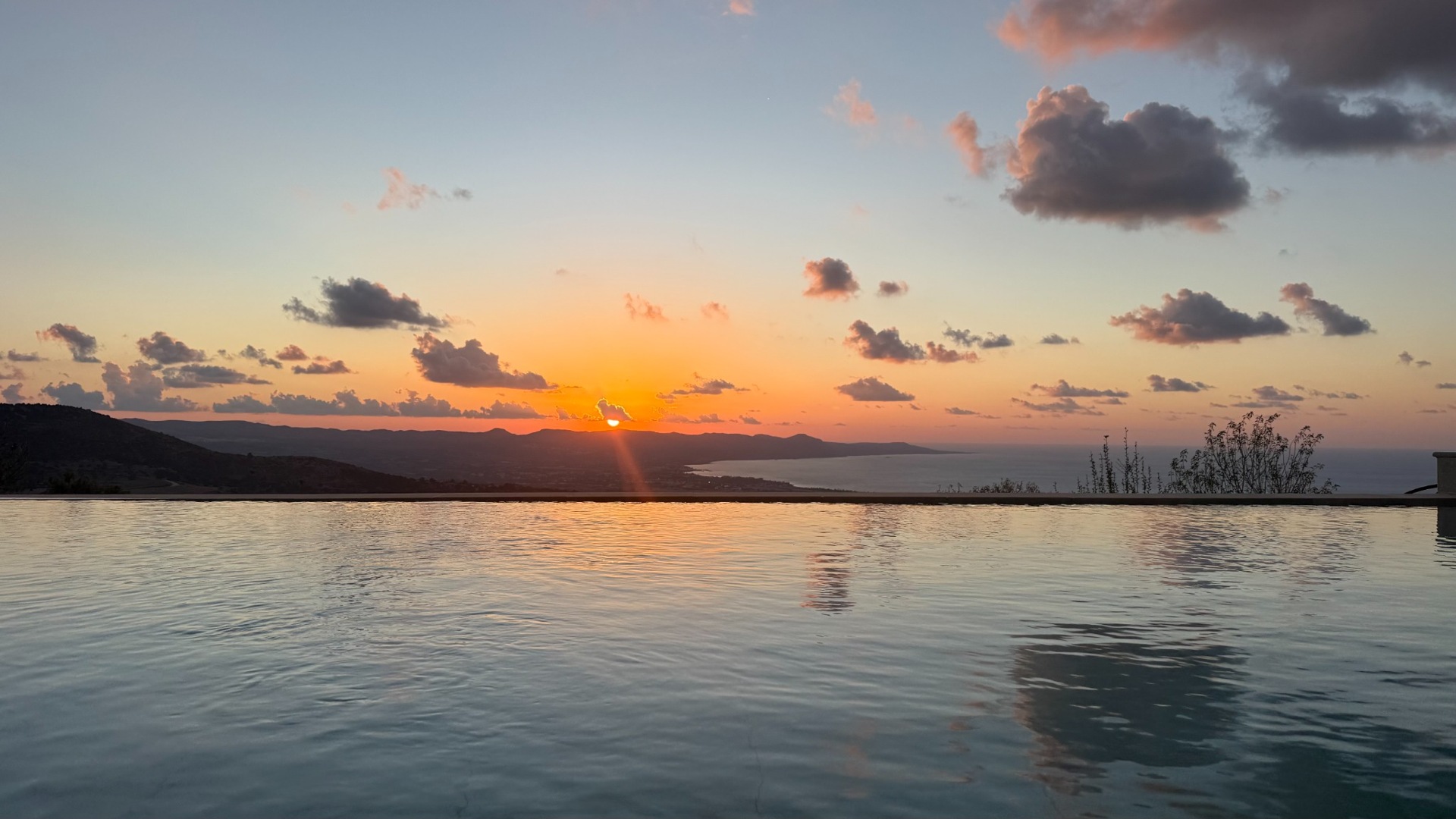 Sunset reflected in the pool with the sea beyond